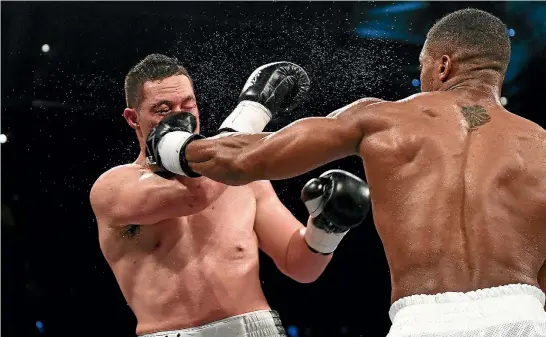  ?? PHOTO: PHOTOSPORT ?? Joseph Parker cops a left to the face from Anthony Joshua during their unificatio­n title fight. ‘‘I have to take it on the chin,’’ the New Zealander said of his defeat.