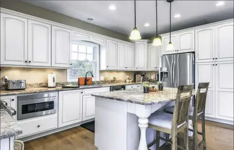  ??  ?? The 20-by-17-foot kitchen has granite counter tops. Appliances include a Samsung five-burner range, Sharp drawer microwave and Bosch dishwasher.