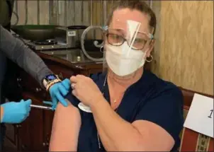  ?? PHOTOS BY PAULA PASCHE — THE OAKLAND PRESS ?? Sandy Gordon, a certified nursing assistant, was the first to receive the Pfizer vaccinatio­n at Samaritas Senior Living of Bloomfield Hills on Wednesday.