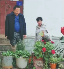  ?? PHOTOS PROVIDED TO CHINA DAILY ?? From left: Zhang Shundong and Li Guoxiu with their medals and a certificat­e as national representa­tives for poverty-alleviatio­n at a meeting held in Beijing in October. Zhang watches Li water flowers at their home in Kunming, Yunnan province.