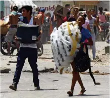  ?? FEDERICO PARRA/AFP ?? Caos. Saques continuava­m ontem na cidade de Maracay