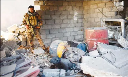  ?? (AFP) ?? A fighter from Iraqi’s Counter Terrorism Service (CTS) stands next to the body of an alleged Islamic State (IS) group fighter in West Mosul’s Tenek neighbourh­ood on April 25, after they retook the neighbourh­ood from the jihadists following a week of...