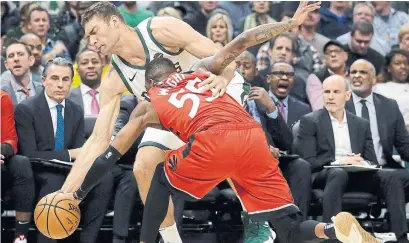  ?? AARON GASH THE ASSOCIATED PRESS ?? Milwaukee's Brook Lopez and Toronto’s Delon Wright fight for a loose ball in Milwaukee. The Raptors beat the Bucks 123-116, their first win over Milwaukee this season. Get game coverage at thestar.com.