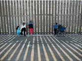  ??  ?? People hold conversati­ons through the US Mexico border wall at Border Field State Park in San Diego, California.