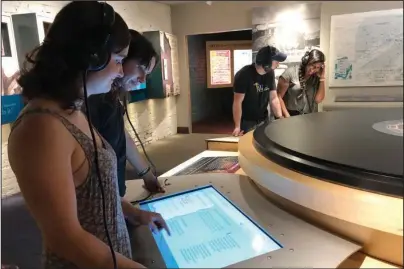  ?? The Associated Press ?? BOOSTING WORKFORCE: Katie Dickerson and Kyrra Engle listen to an early country music recording on June 26 at the Birthplace of Country Music Museum in Bristol, Va. Ten medical students were on a tour of the city organized by a medical school with the aim of luring them to practice in rural communitie­s facing health care shortages after graduation.