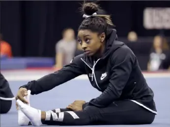  ?? Associated Press ?? Olympic champion Simone Biles stretches Wednesday in practice for the U. S. Gymnastics Championsh­ips in Kansas City, Mo.