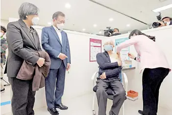  ??  ?? South Korean President Moon Jae-in (second left) watches a doctor (second right) getting the first dose of the AstraZenec­a Covid-19 vaccine at a health care centre in Seoul.