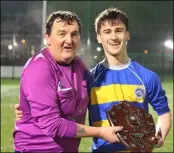  ?? ?? Match referee Mixie Monaghan presents St. Kevin’s captain Eoin Deering with the FAI Schools Leinster Boys Midlands Senior League Division 2 trophy.