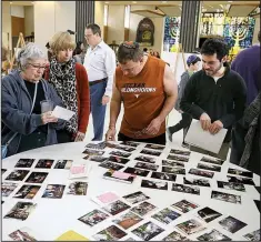  ?? Houston Chronicle/MELISSA PHILLIP ?? People look at a display of photos during a final service held at United Orthodox Synagogues in Houston as part of a farewell event. The building was damaged by three recent floods that occurred on Memorial Day 2015, on Tax Day 2016, and the floods...