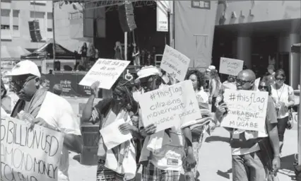  ?? ALICIA WYNTER, SPECIAL TO THE RECORD ?? Members of the Zimbabwe Canada Associatio­n of Waterloo march in Victoria Park Saturday against human rights violations in Zimbabwe.