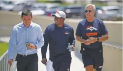  ?? DAVID ZALUBOWSKI/ASSOCIATED PRESS ?? Denver Broncos general manager John Elway, right, and head coach Vance Joseph, center, joke with Patrick Smyth, executive vice president of public and community relations, on Friday at the team’s headquarte­rs in Englewood, Colo.