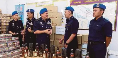  ?? [FOTO ADI SAFRI/BH] ?? Khon Chiang (tengah) bersama barang rampasan di Jeti Pasukan Polis Marin, Muar.