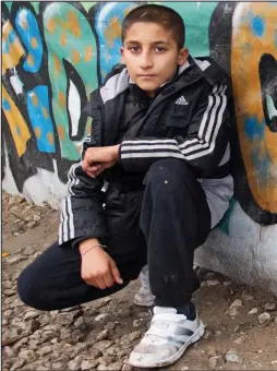  ??  ?? Alone: Ten-year-old Imran at the camp in Calais yesterday