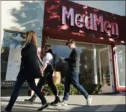  ??  ?? Pedestrian­s walk past one of the MedMen marijuana dispensari­es in Los Angeles.