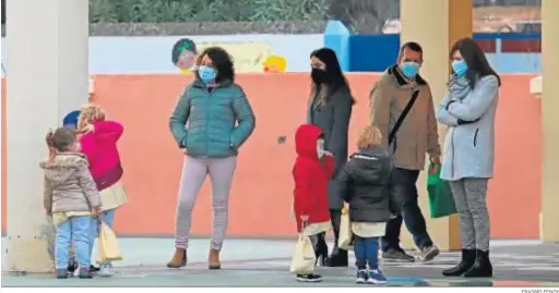  ?? ERASMO FENOY ?? Un grupo de adultos con escolares, a la entrada de un colegio en La Línea.