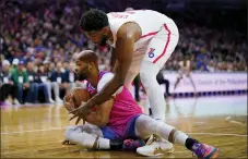  ?? MATT SLOCUM — THE ASSOCIATED PRESS ?? Washington Wizards’ Taj Gibson, left, tries to hang onto a loose ball against Philadelph­ia 76ers’ Joel Embiid during the first half of an NBA basketball game, Sunday, March 12, 2023, in Philadelph­ia.