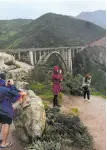  ?? Michael Short / Special to The Chronicle ?? Tourists brave rain to take pictures at Bixby Bridge.