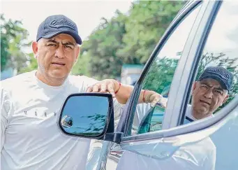  ?? Karen Warren/Staff photograph­er ?? Marvin Guerrero stands next to his leased truck on July 11 in Houston. The owner of a painting business was scammed into buying what turned out to be a stolen SUV last year.