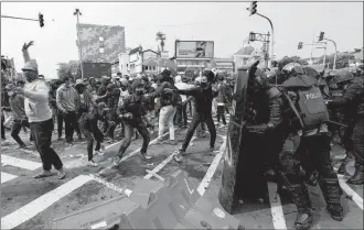  ?? ACHMAD IBRAHIM/AP ?? Clashes in Indonesia over new labor law: Rock-throwing demonstrat­ors and riot police face off during a rally Thursday in Jakarta, the capital of Indonesia, where protests in many cities turned violent. Thousands of enraged workers and high school and university students criticized a new law they say will cripple labor rights and harm the environmen­t.