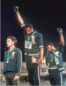  ?? AP ?? Tommie Smith, center, and John Carlos extend gloved hands in racial protest at the 1968 Olympics.