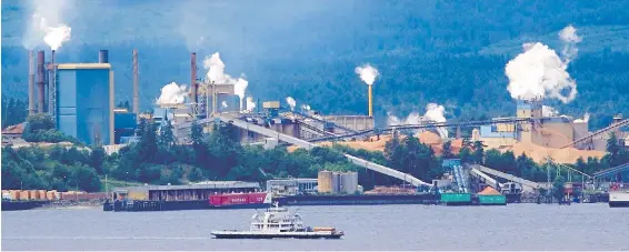  ??  ?? A ferry passes the Catalyst Paper mill in Crofton on its way to Vesuvius Bay on Salt Spring Island.