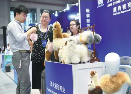  ?? XINHUA ?? A man looks at wool products from Australia at an import fair in Shanghai on July 26.