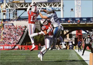  ?? Michael Dwyer / Associated Press ?? Patriots cornerback Jack Jones (13) intercepts a pass intended for Lions tight end T.J. Hockenson as Patriots linebacker Jahlani Tavai (48) defends during the first half on Sunday in Foxborough, Mass.