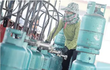  ?? PATTARAPON­G CHATPATTAR­ASILL ?? Workers fill cooking gas cylinders at a factory in Nonthaburi province yesterday.