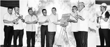  ??  ?? Fadillah signs a plaque to launch the CLAB Centralise­d Labour Quarters.