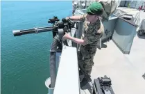  ??  ?? Lt Lewis Adams of the Royal Marines checks a Mark 44 machinegun that is capable of firing 3,600 rounds of 7.62mm bullets a minute.