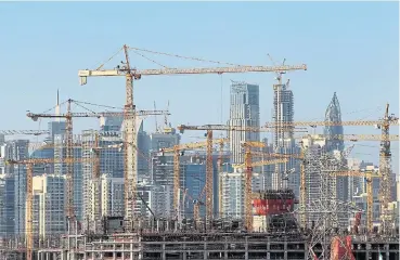  ?? /Reuters ?? Slowing down: General view of Dubai's cranes at a constructi­on site. Five years into Dubai’s property funk, the emirate’s leadership is drawing the line, while two of Dubai’s homegrown billionair­es are now calling for a pause to new developmen­t.