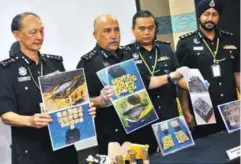  ?? BERNAMAPIX ?? Mokhtar (second left) and Bukit Aman's NCID deputy director Kang Chez Chiang (left) showing pictures of the seized drugs at the press conference in Bukit Aman yesterday.