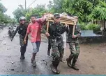  ??  ?? Villagers carry the body of a victim after flash floods in Lembata, East Flores Monday as torrential rains triggered floods and landslides that have killed at least 91 people and left dozens missing in Indonesia and neighborin­g East Timor. —AFP