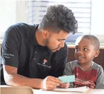  ?? RICK WOOD / MILWAUKEE JOURNAL SENTINEL ?? Patrick Jagiello instructs Tarrell Harvey on how to write the letters of his name. Jagiello works at Next Door Foundation as part of the Leading Men Fellows, a program created by the Washington, D.C.-based Literacy Lab to boost literacy skills in early childhood and expose young men of color to jobs in early childhood education.