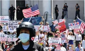  ??  ?? Demonstrat­ors protest in front of Los Angeles City Hall last month to demand an end to California’s shutdown. Photograph: Frederic J Brown/AFP via Getty Images