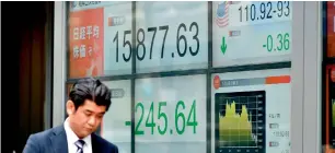  ?? — AFP ?? A share prices board of the Tokyo Stock Exchange. In Asia and Europe, energy companies nursed heavy losses as oil prices fell further.