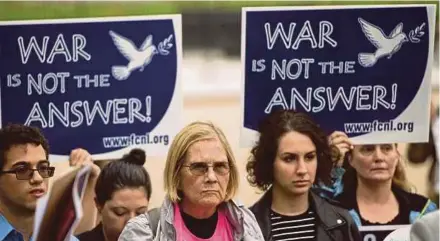  ?? AFP PIC ?? People hold up signs during a protest calling for the Trump administra­tion to continue diplomacy with Iran near the White House in Washington.