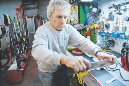  ?? Photos by Hyoung Chang, The Denver Post ?? Corky Grimm, owner of Green Mountain Sports in Lakewood, demonstrat­es ski preparatio­n for the upcoming season. Ski shops also do a safety check on gear when customers bring gear in for a tune.