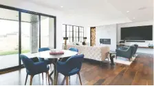  ??  ?? The open dining area and the walkout basement show just how much natural light enters the home through the huge windows encased in black.