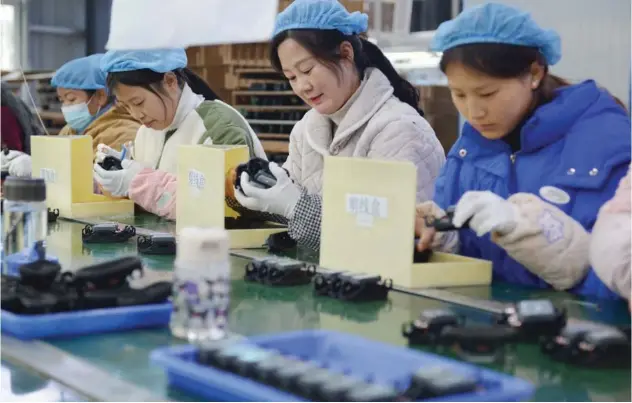  ?? Agence France-presse ?? ↑
Employees work on an assembly line producing speakers at a factory in Fuyang city, in China’s eastern Anhui province.