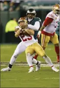  ?? CHRIS SZAGOLA — THE ASSOCIATED PRESS ?? 49ers running back Christian McCaffrey (23) is literally wrapped up by Eagles defensive end Robert Quinn during the NFC championsh­ip game (98) Jan. 29 at Lincoln Financial Field.