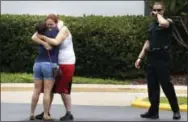  ?? THE ASSOCIATED PRESS ?? People console each other after a deadly shooting Monday in Orlando, Fla.