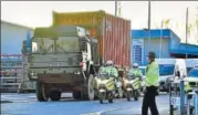  ?? AFP ?? Police officers escort an army truck carrying a freight container laden with the car of Sergei Skripal in Salisbury.