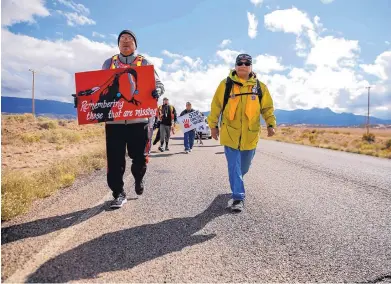  ?? JON AUSTRIA/FARMINGTON DAILY TIMES ?? John Tsosie, co-founder of Walking the Healing Path, left, and Gary Mike, father of Ashlynne Mike, walk along Navajo Route 13 in Red Valley, Ariz., on Oct. 18. Community members walked from Window Rock, Ariz., to Shiprock, N.M., to raise awareness about the issue of murdered and missing indigenous women.