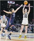  ?? MORRY GASH, THE ASSOCIATED PRESS ?? Iowa guard Caitlin Clark shoots a three-pointer over UConn guard Nika Muhl during the second half of their Final Four semifinal game in Cleveland on Friday.