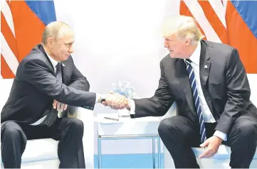  ??  ?? Trump (right) and Putin shake hands during a meeting on the sidelines of the G20 Summit in Hamburg. — AFP photo