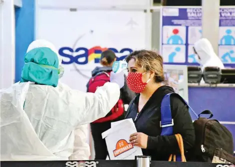  ?? CARLOS LÓPEZ ?? El personal del aeropuerto controla la temperatur­a a pasajera que aborda un vuelo solidario, el jueves.