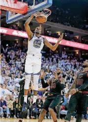  ?? [AP PHOTO] ?? Golden State’s Kevin Durant dunks in front of Cleveland’s LeBron James, left, and Jae Crowder during Monday’s game in Oakland, Calif.