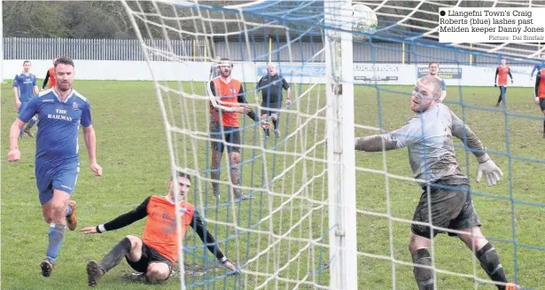  ?? Picture: Dai Sinclair ?? Llangefni Town’s Craig Roberts (blue) lashes past Meliden keeper Danny Jones