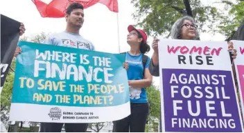  ?? — AFP ?? Environmen­tal activists display placards during a demonstrat­ion in front of the United Nations building, where experts from across the planet locked in key talks aimed at breathing life into the Paris Agreement on climate change in Bangkok.